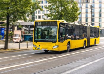 Ônibus urbano articulado amarelo transporte público no centro da cidade