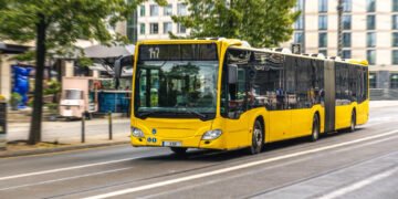 Ônibus urbano articulado amarelo transporte público no centro da cidade